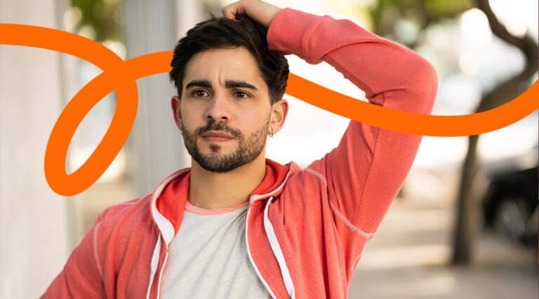 Portrait of a man with a trimmed beard in a coral hoodie, outdoors, with an orange curved branding swoosh across the image.